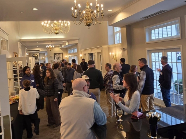 Attendees gathering and socializing near the buffet and bar area at the AMWS annual meeting.